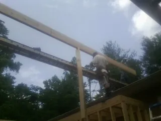 Carpenter setting a ridge beam over a new addition frame — Ice Dam Removal by Roofing Brothers in Forest Hills