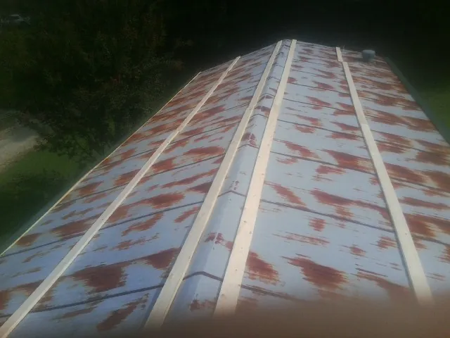 Rusted metal roof panels with new wood purlins before replacement — Storm Damage Roof Repair in Forest Hills by Roofing Brothers